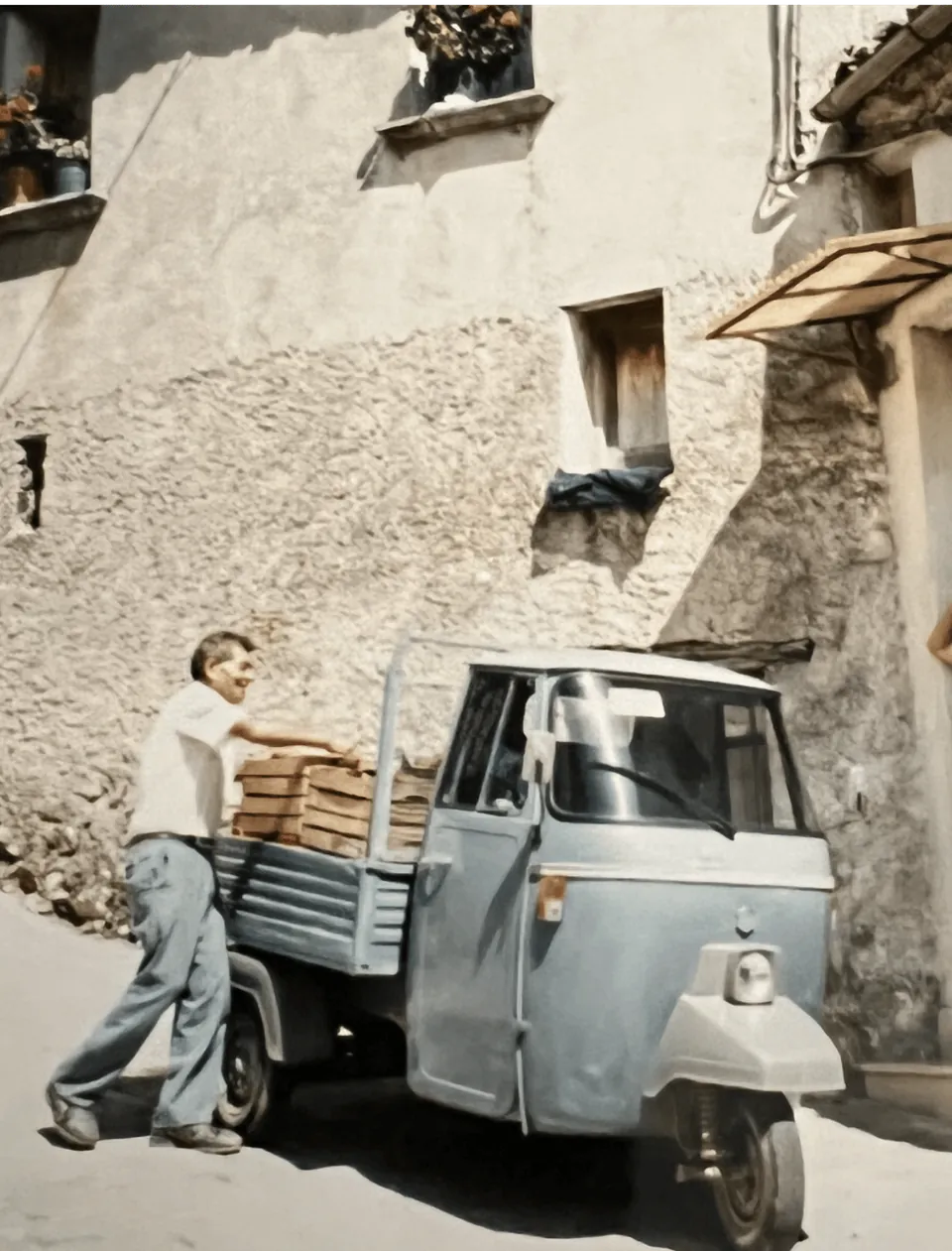 Ape-Dreirad mit Holzkisten vor einem Haus in einer italienischen Gasse