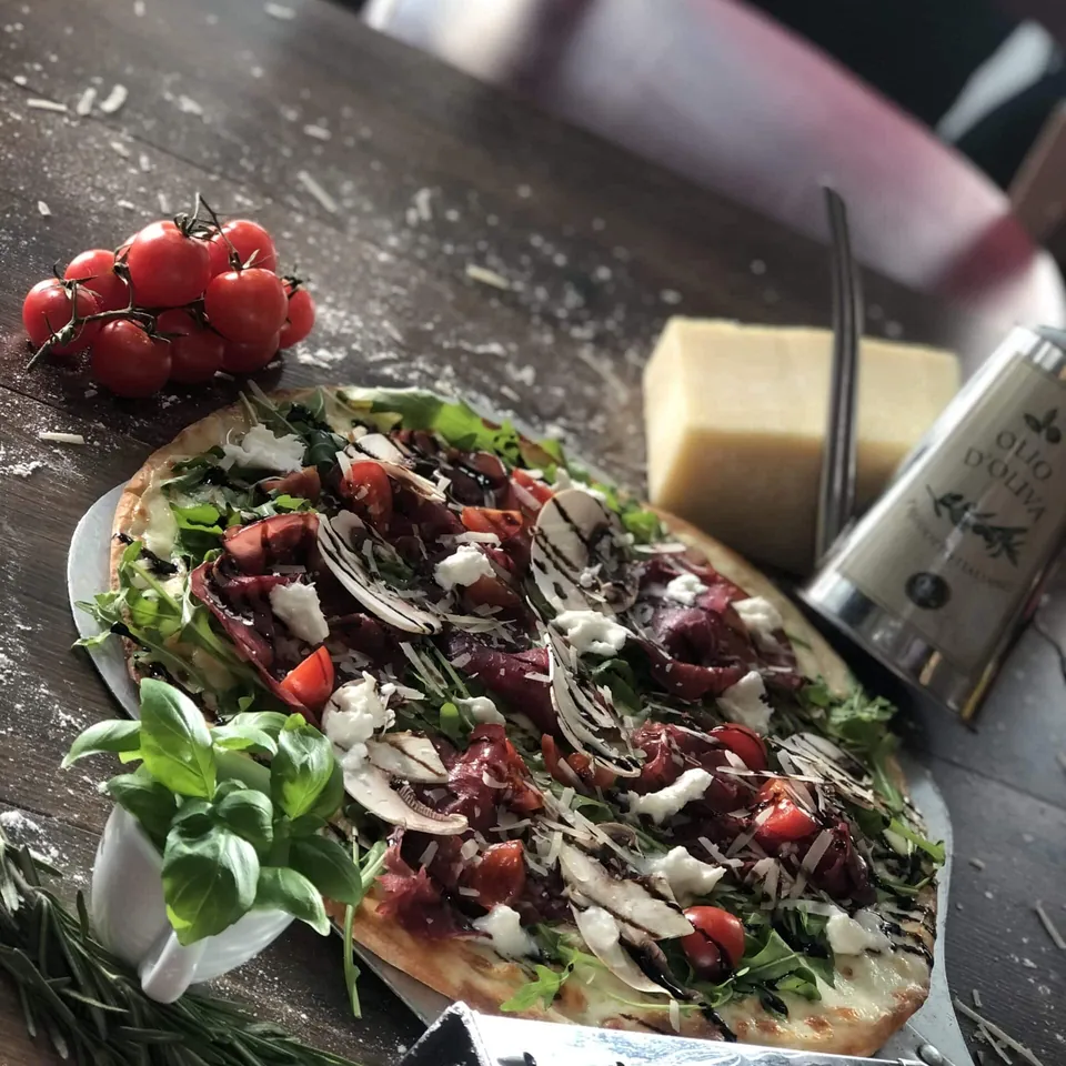 Pizza mit Bresaola, Rucola und Kirschtomaten